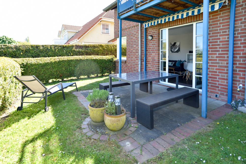 Außenansicht der Terrasse mit Sitzmöglichkeit und einer kleiner Rasenfläche